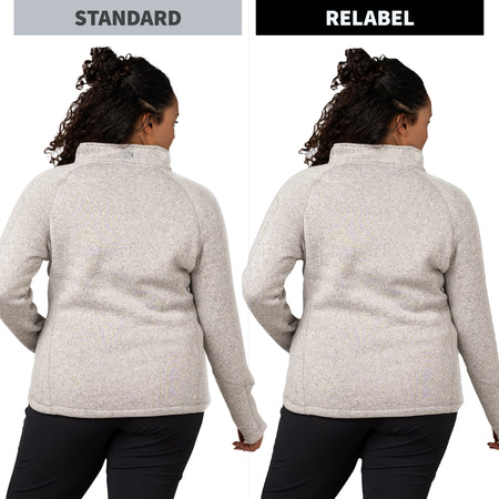 Side-by-side comparison of a woman from the back wearing a light heather gray quarter-zip fleece. The left side is labeled 'STANDARD' and shows a slightly slouchier fit, while the right side is labeled 'RELABEL' and shows a tighter, flatter fit.